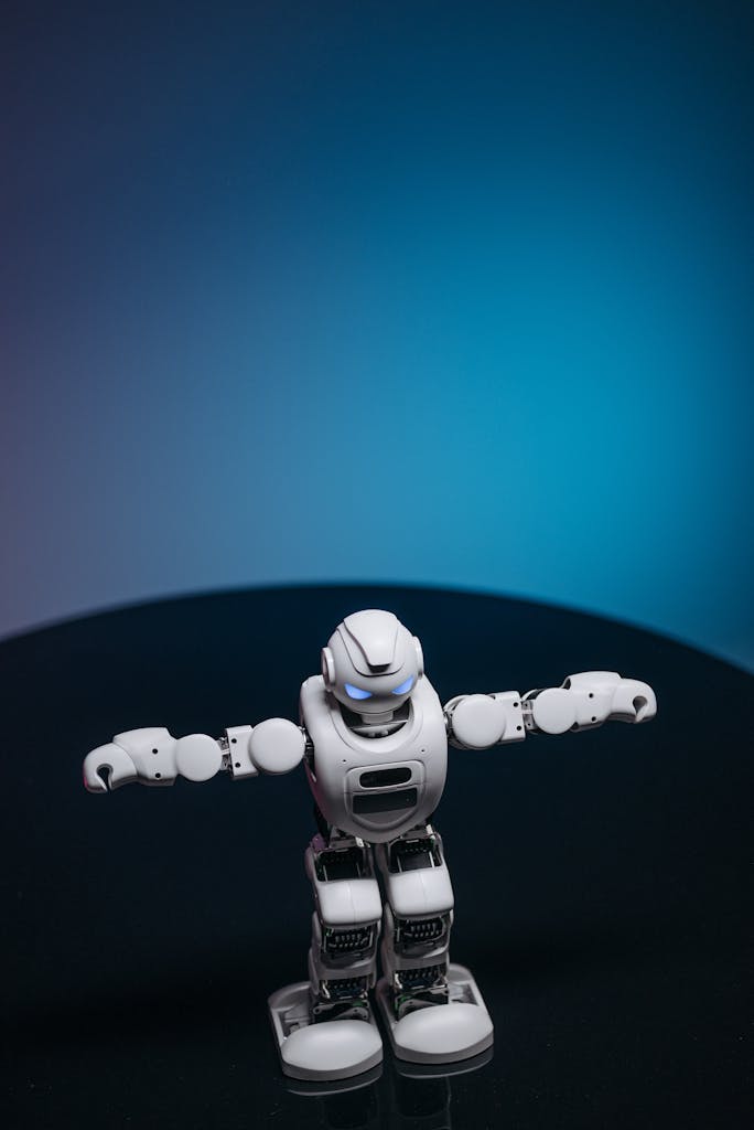 White toy robot with glowing eyes posed in a studio setting against a dark background.